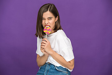 Image showing The young woman with colorful lollipop