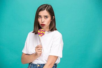 Image showing The young woman with colorful lollipop