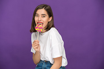 Image showing The young woman with colorful lollipop
