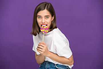 Image showing The young woman with colorful lollipop