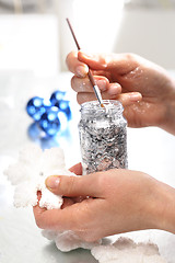 Image showing Woman decorate baubles. Christmas tree decorations