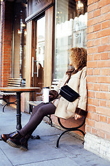 Image showing young pretty african american women drinking coffee outside in c