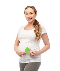 Image showing happy pregnant woman with green house