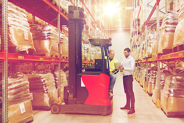 Image showing men with tablet pc and forklift at warehouse