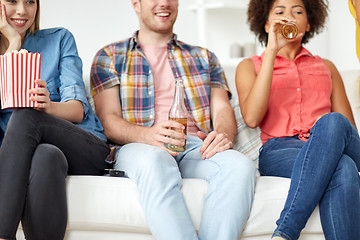 Image showing close up of friends with popcorn and beer at home