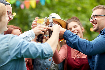 Image showing happy friends clinking glasses at summer garden