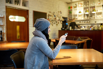 Image showing young woman with smartphone at cafe