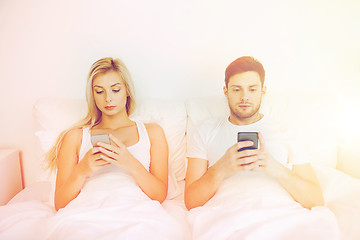 Image showing couple with smartphones in bed