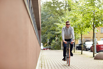 Image showing young man riding bicycle on city street