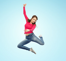 Image showing smiling young woman jumping in air