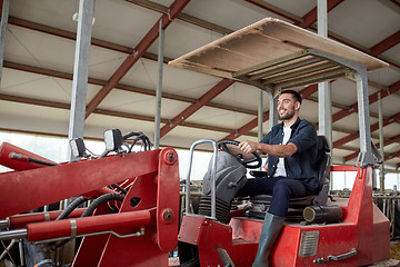 Image showing man or farmer driving tractor at farm