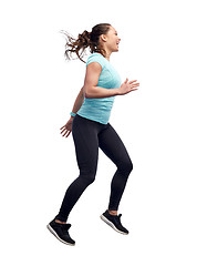 Image showing happy smiling sporty young woman jumping in air