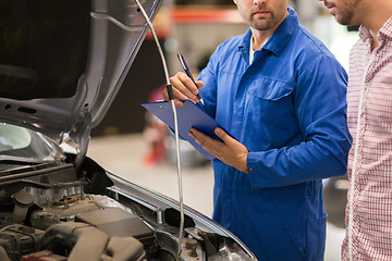 Image showing auto mechanic with clipboard and man at car shop