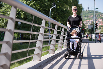 Image showing mother pushed her baby daughter in a stroller