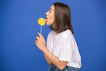 Image showing The young woman with colorful lollipop