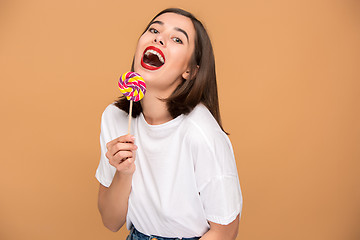 Image showing The young woman with colorful lollipop