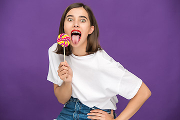 Image showing The young woman with colorful lollipop