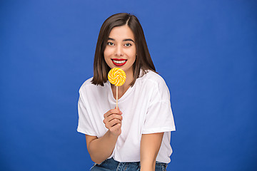 Image showing The young woman with colorful lollipop