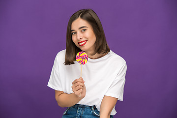 Image showing The young woman with colorful lollipop