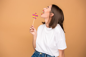 Image showing The young woman with colorful lollipop