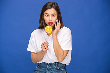 Image showing The young woman with colorful lollipop