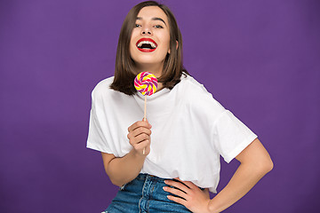 Image showing The young woman with colorful lollipop