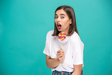 Image showing The young woman with colorful lollipop