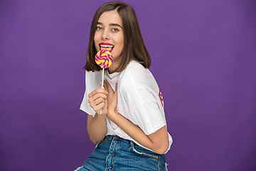 Image showing The young woman with colorful lollipop