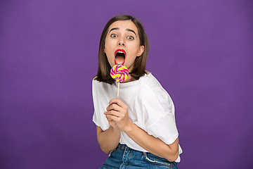 Image showing The young woman with colorful lollipop