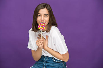 Image showing The young woman with colorful lollipop