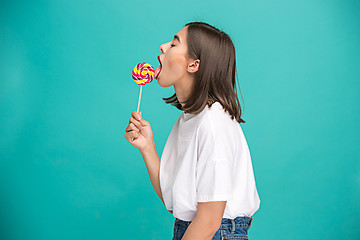 Image showing The young woman with colorful lollipop