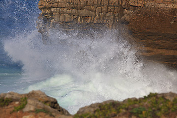 Image showing Marine wave breaks against offshore stone