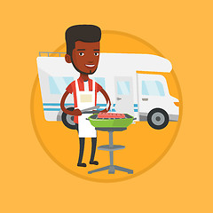 Image showing Man having barbecue in front of camper van.