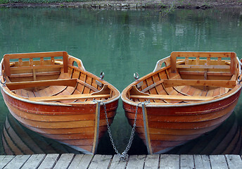 Image showing Rowboats parked in a row near a clear water lake