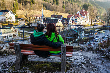 Image showing Couple sitting on bench near mountains