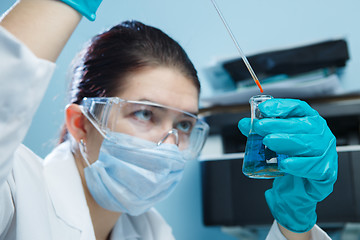 Image showing Laboratorian with safety glasses, flask