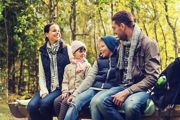 Image showing happy family sitting on bench and talking at camp