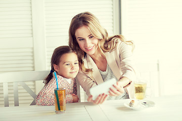 Image showing happy family taking selfie at restaurant