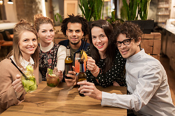 Image showing happy friends with drinks at bar or cafe