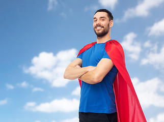 Image showing happy man in red superhero cape over blue sky