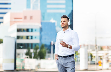 Image showing man with headphones and smartphone listening music