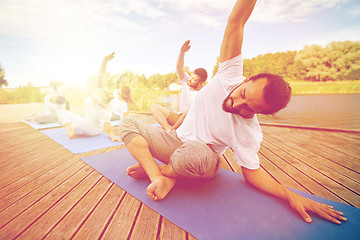 Image showing group of people making yoga exercises outdoors