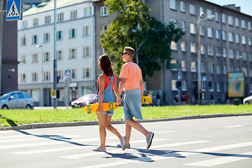 Image showing teenage couple with skateboards on city crosswalk