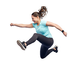 Image showing happy smiling sporty young woman jumping in air