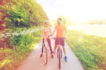 Image showing happy couple riding bicycle outdoors