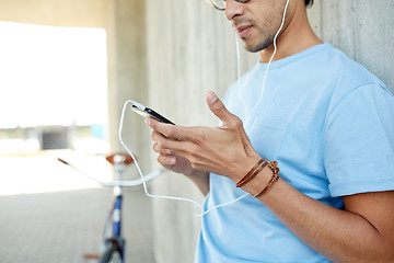 Image showing man with earphones and smartphone listening music