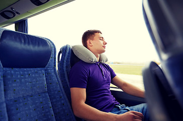 Image showing happy young man sleeping in travel bus with pillow