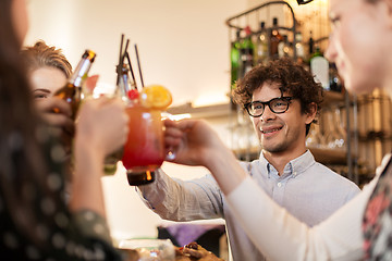 Image showing happy friends clinking drinks at bar or cafe