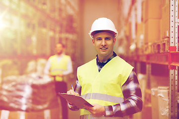 Image showing man with clipboard in safety vest at warehouse