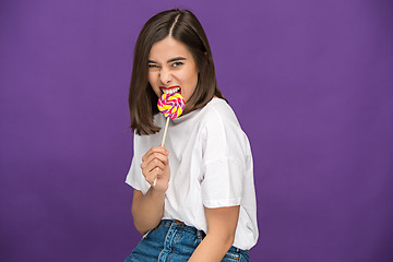 Image showing The young woman with colorful lollipop